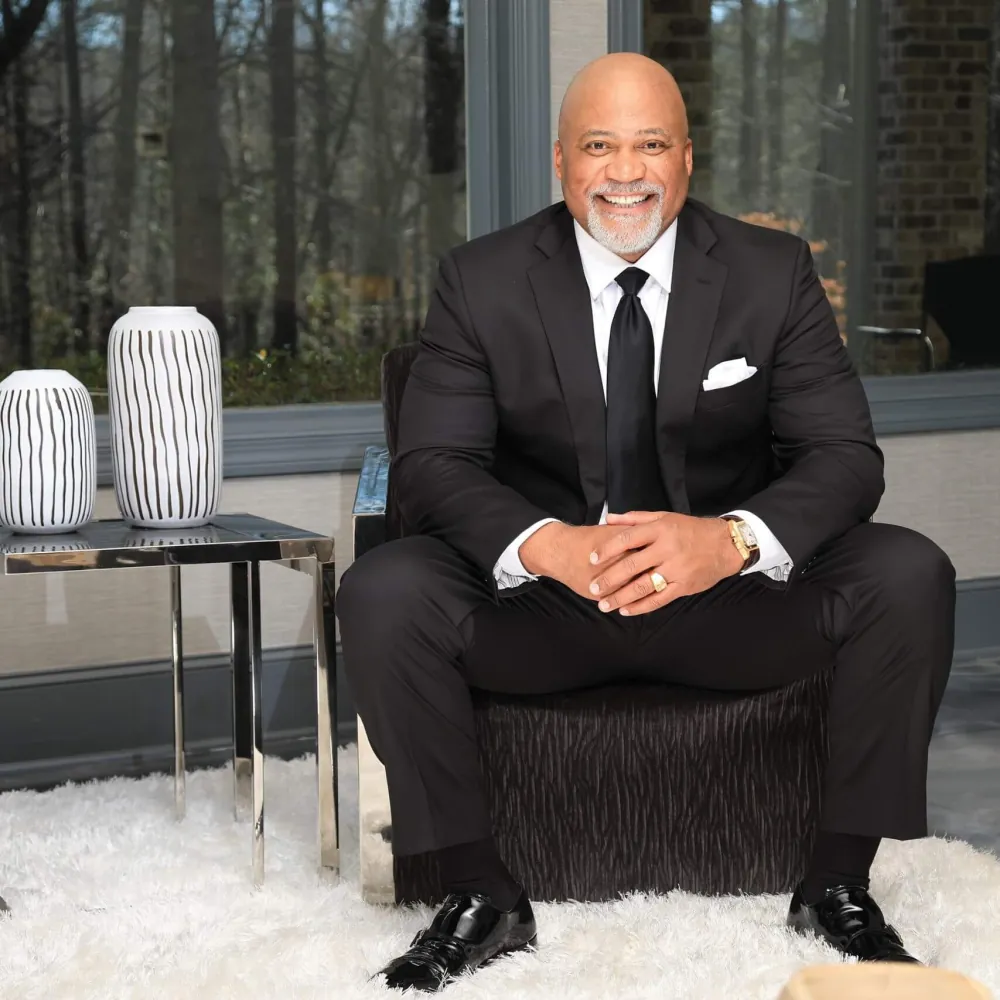Dr. Cooper in a black suit, seated